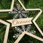 Suspension artisanale en forme d’étoile, bois gravé et paillettes